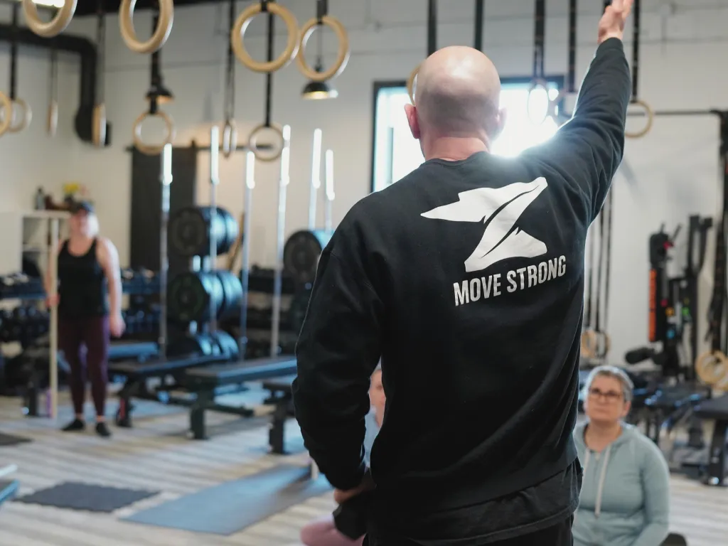 Coach demonstrating movement at Move Strong in Kitchener-Waterloo