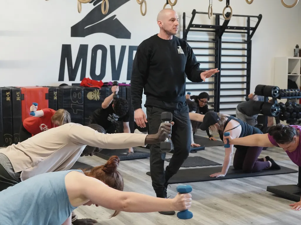 Coach guiding a Rebuild mobility session at Move Strong