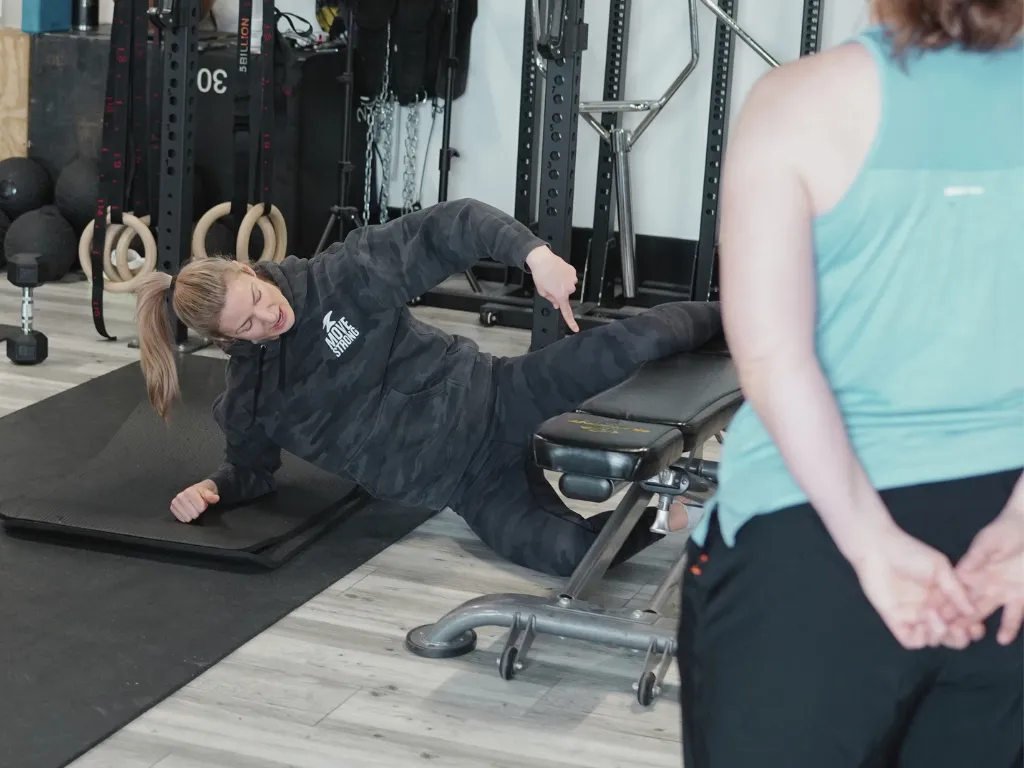 Move Strong coach guiding a member through proper form during class in Kitchener-Waterloo